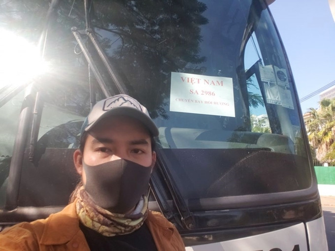 Đăng Khoa chụp ảnh bên chuyến xe chở công dân Việt Nam hồi hương. Phượt thủ Việt vòng quanh thế giới phải hồi hương vì Covid-19
