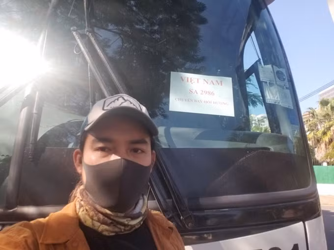 Đăng Khoa chụp ảnh bên chuyến xe chở công dân Việt Nam hồi hương. Phượt thủ Việt vòng quanh thế giới phải hồi hương vì Covid-19