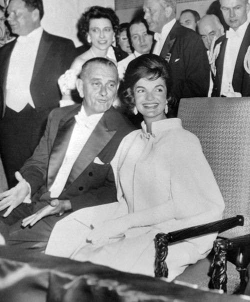 Jacqueline Kennedy, 1961 Là một trong 10 đệ nhất phu nhân Mỹ ảnh hưởng tới thời trang, Jackie Kennedy từ nhỏ đã quen với cuộc sống nhung lụa và sở hữu gu thẩm mỹ tinh tế, thanh lịch. Trước lễ nhậm chức của chồng, bà đã tự tay phác thảo xiêm y để Ethel Frankau của thương hiệu Bergdorf Goodman thực hiện dựa trên đó. Set đồ gồm áo cape mặc ngoài váy lụa chiffon được nhiều chuyên gia đánh giá cao bởi sự sang trọng, đơn giản mà cuốn hút. xiem y cac de nhat phu nhan my qua 15 le nham chuc tong thong