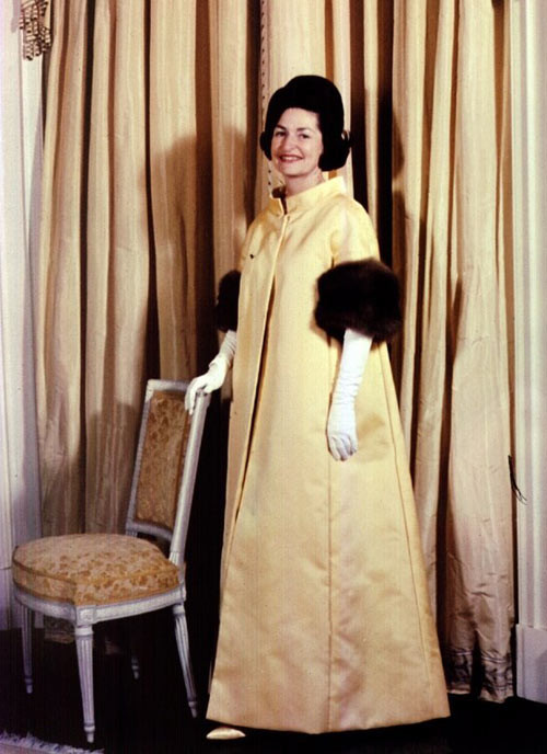 Lady Bird Johnson, 1963 Trang phục dáng cape đính lông này được hãng bán lẻ nổi tiếng Neiman Marcus (chi nhánh Texas) đặt hàng John Moore thiết kế cho người phụ nữ quyền lực nhất nước Mỹ. xiem y cac de nhat phu nhan my qua 15 le nham chuc tong thong