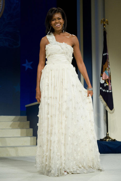 Michelle Obama, 2009 Sau khi được biên tập viên André Leon Talley của tạp chí Vogue giới thiệu với tân đệ nhất phu nhân Mỹ, nhà thiết kế gốc Á Jason Wu đã sáng tạo mẫu đầm lệch vai màu trắng ngà này để Michelle diện trong lễ nhậm chức của chồng. Đây là một cú hích ngoạn mục đối với sự nghiệp của Jason Wu, giúp anh ghi dấu tên tuổi trong ngành thời trang thế giới. xiem y cac de nhat phu nhan my qua 15 le nham chuc tong thong