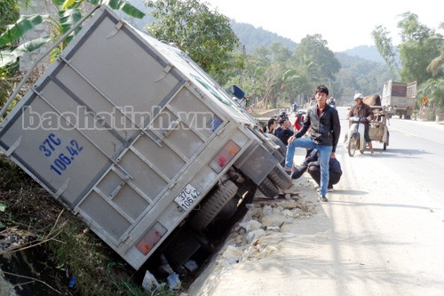 Nổ lốp, xe tải "đánh võng" rồi mắc kẹt dưới mương nước bên đường ảnh 1