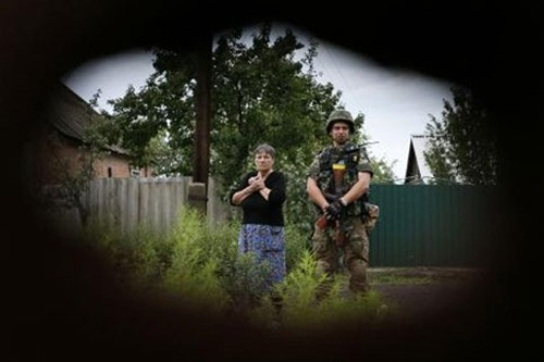 Lính Ukraine đứng cạnh một người dân tại làng Semenovka, gần Sloviansk, Đông Ukraine - Ảnh: Reuters.