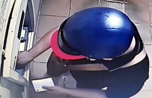 Trần Thế Bảo đang gắn thiết bị đọc trộm thông tin tại một trụ ATM ở quận Ninh Kiều. Ảnh: Công an cung cấp. thu doan cua nhom trom tien ty bang the atm gia o mien tay