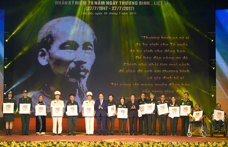 Thủ tướng Nguyễn Xuân Phúc tặng quà cho các đại biểu người có công. - Ảnh: VGP/Quang Hiếu thu tuong chung ta nguyen song xung dang voi nhung cong hien hy sinh cua dong chi dong bao