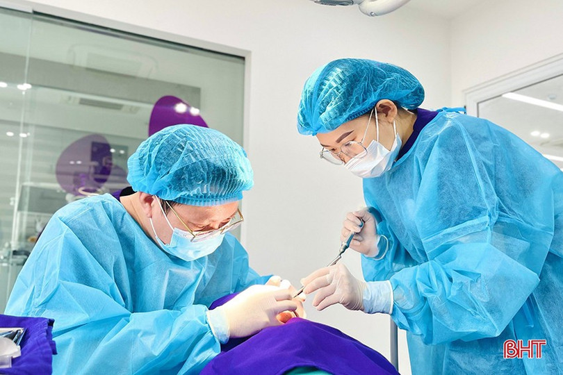 Bác sỹ Phạm Tiến Hùng (bên trái) thực hiện cấy răng implant cho bệnh nhân. implant-2-9218.jpg