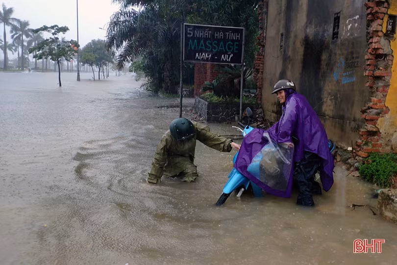 Phần lớn tuyến đường ngập sâu, người dân TP Hà Tĩnh bì bõm di chuyển về nhà