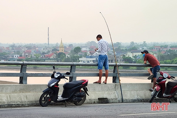 Thản nhiên câu cá trên cầu Cửa Hội nối Nghệ An - Hà Tĩnh