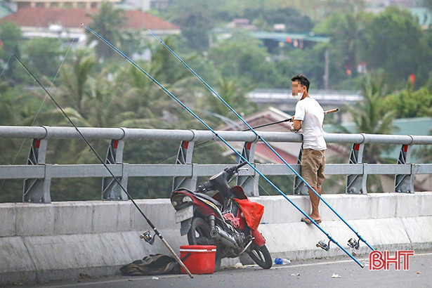 Thản nhiên câu cá trên cầu Cửa Hội nối Nghệ An - Hà Tĩnh