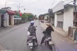 2 phụ nữ dừng xe máy giữa đường nói chuyện, ôtô không thể di chuyển