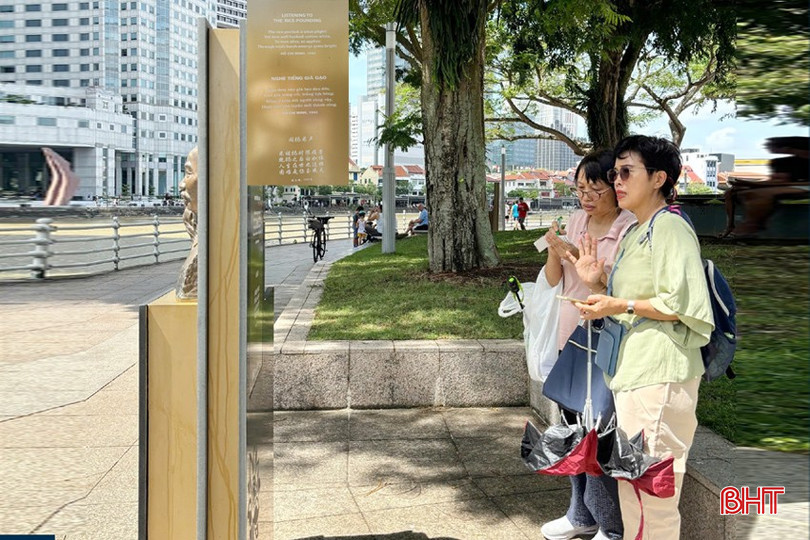 Du khách chăm chú đọc, ghi chép bài thơ "Nghe tiếng giã gạo" được khắc ghi trên văn bia. bqbht_br_v3-copy.jpg
