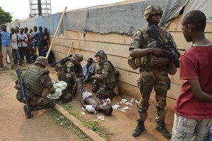 Binh sỹ Pháp giúp đỡ người bị thương trong các vụ cướp phá tại Bangui. (Ảnh: AFP/TTXVN)