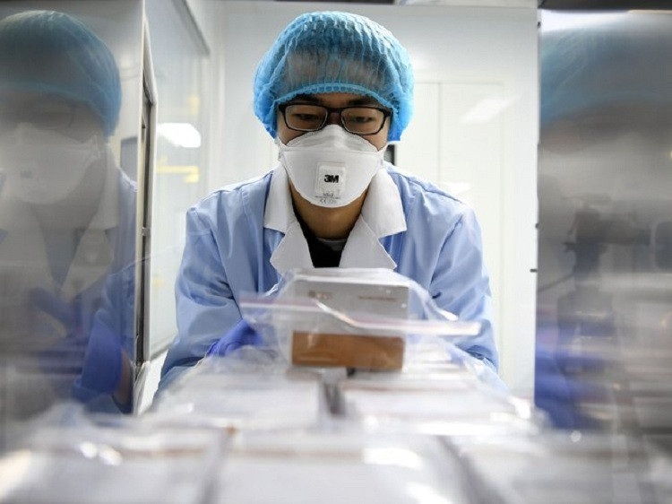 Nhà khoa học cất thuốc thử phát hiện nCoV tại VũThanh, phía bắc thành phố Thiên Tân của Trung Quốc. Ảnh: Shutterstock Canh bạc tỷ đô cho vaccine và thuốc Covid-19