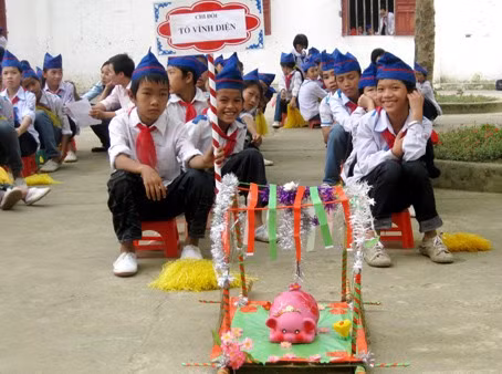 Heo đất được trang trí bằng nhiều màu sắc và được các em học sinh rước trên những chiếc kiệu trang trọng đi một vòng sân trường trong sự cổ vũ, reo hò của các bạn Heo đất được trang trí bằng nhiều màu sắc và được các em học sinh rước trên những chiếc kiệu trang trọng đi một vòng sân trường trong sự cổ vũ, reo hò của các bạn