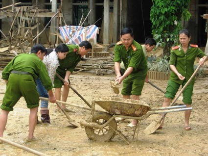 Cán bộ, chiến sĩ Công an Hà Tĩnh giúp dân vùng lũ khắc phục hậu quả.