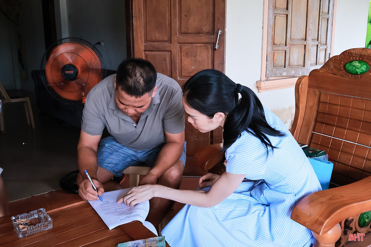 Cán bộ Trung tâm Phát triển Quỹ đất tỉnh chi trả tiền hỗ trợ tạm cư cho các hộ dân.
