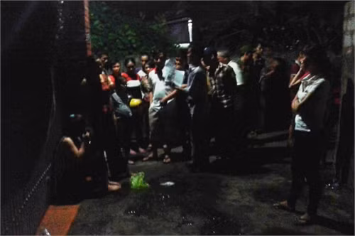 Người nhà bà Xoan đứng trước nhà ông Hòa để đòi nợ - Ảnh: Cảnh Phúc