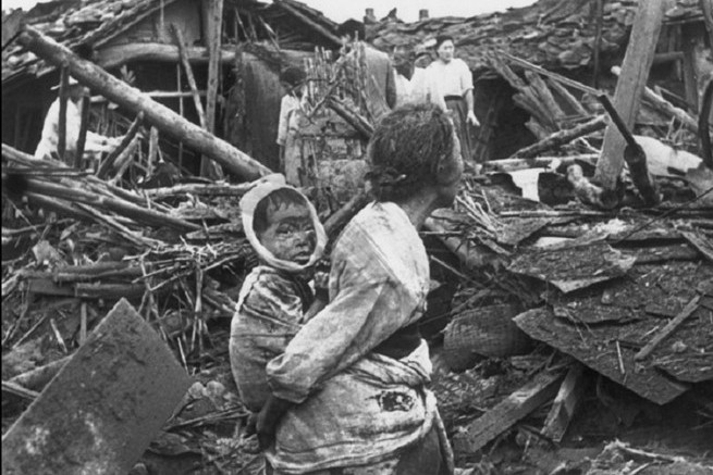 Một phụ nữ cõng theo đứa trẻ giữa đống đổ nát sau cuộc không kích của Mỹ vào Bình Nhưỡng. Ảnh: CNN cuoc chien dam mau tren ban dao trieu tien 64 nam truoc