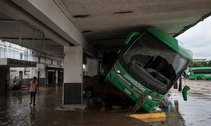 Xe buýt bị nước lũ cuốn vào nhà chờ tại Poza Rica, bang Veracruz, Mexico ngày 11/10. Ảnh: AP Xe buýt bị nước lũ cuốn vào nhà chờ tại Poza Rica, bang Veracruz, Mexico ngày 11/10. Ảnh: AP