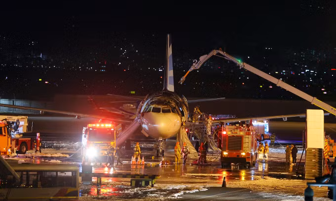 Lính cứu hỏa tìm cách dập lửa trên máy bay của Air Busan tối 28/1. Ảnh: AP