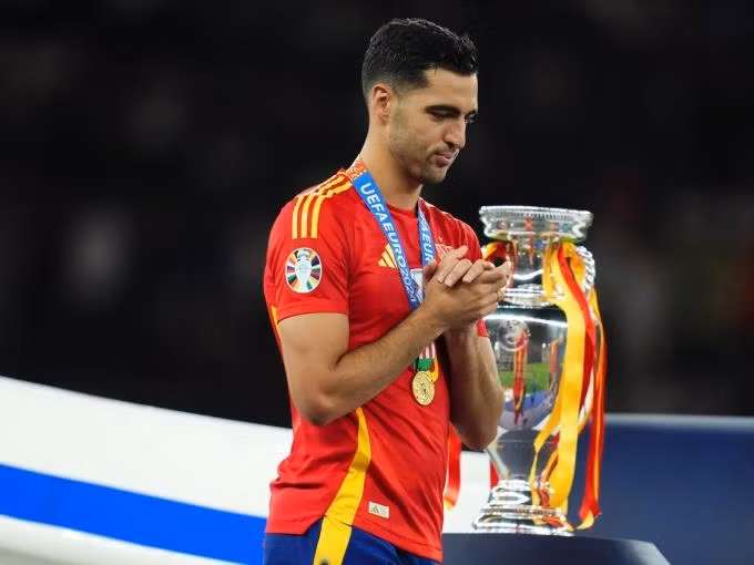 Merino bước qua chiếc cup vô địch Euro 2024 trong lễ đăng quang của tuyển Tây Ban Nha sau trận chung kết trên sân Olympic, Berlin hồi tháng 7. Ảnh: AFP