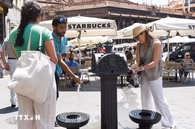 Người dân làm mát tại vòi nước công cộng dưới trời nắng nóng ở Madrid, Tây Ban Nha ngày 29/5/2025. (Ảnh: THX/TTXVN)