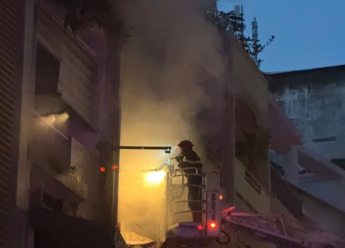 Xe thang giương cao để lính cứu hỏa cứu người mắc kẹt ở lầu 1 và dập lửa. Ảnh: Minh Hoàng