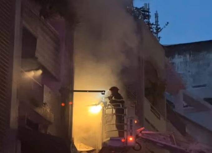 Xe thang giương cao để lính cứu hỏa cứu người mắc kẹt ở lầu 1 và dập lửa. Ảnh: Minh Hoàng