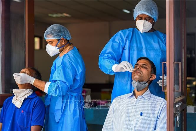 Nhân viên y tế lấy mẫu dịch xét nghiệm COVID-19 cho người dân tại New Delhi, Ấn Độ. Ảnh tư liệu: AFP/TTXVN Nhân viên y tế lấy mẫu dịch xét nghiệm COVID-19 cho người dân tại New Delhi, Ấn Độ. Ảnh tư liệu: AFP/TTXVN