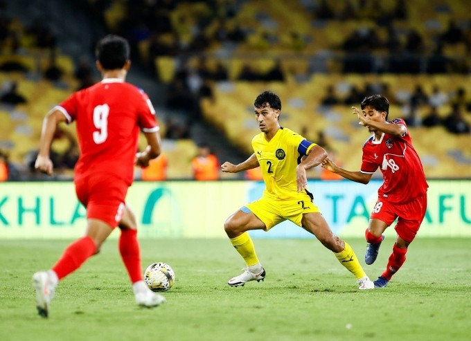 Hậu vệ Malaysia lai Australia Matthew Davies (áo vàng) thi đấu trong trận thắng Nepal 1-0 ở lượt năm bảng F vòng loại cuối Asian Cup 2027, trên sân Bukit Jalil ở Kuala Lumpur ngày 18/11/2025. Ảnh: MalaysiaNT