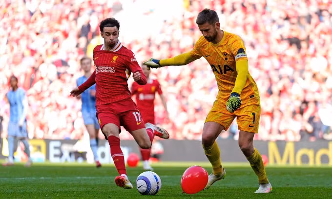 Tiền vệ Curtis Jones tranh bóng với thủ môn Guglielmo Vicario, cùng một quả bóng bay màu đỏ. Ảnh: AP