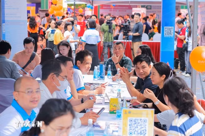 Phụ huynh và thí sinh tìm hiểu thông tin các trường đại học, cao đẳng. (Ảnh: Hoàng Hiếu/TTXVN)