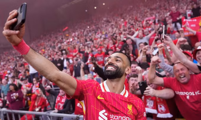 Salah lấy điện thoại của khán giả để selfie sau khi ghi bàn nâng tỷ số lên 4-1 cho Liverpool trước Tottenham. Ảnh: AP