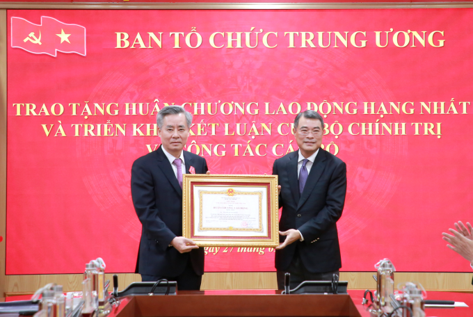 Trưởng ban Tổ chức Trung ương Lê Minh Hưng trao tặng Huân chương Lao động hạng Nhất cho ông Nguyễn Quang Dương. Ảnh: Cổng thông tin Đảng Cộng sản