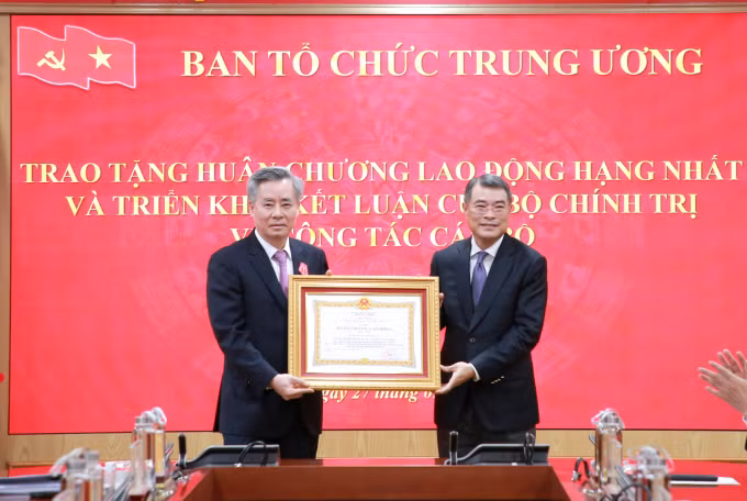 Trưởng ban Tổ chức Trung ương Lê Minh Hưng trao tặng Huân chương Lao động hạng Nhất cho ông Nguyễn Quang Dương. Ảnh: Cổng thông tin Đảng Cộng sản