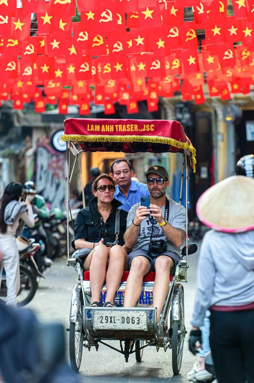 Khách quốc tế ngồi xích lô dạo phố cổ Hà Nội. Ảnh: Đinh Hà.