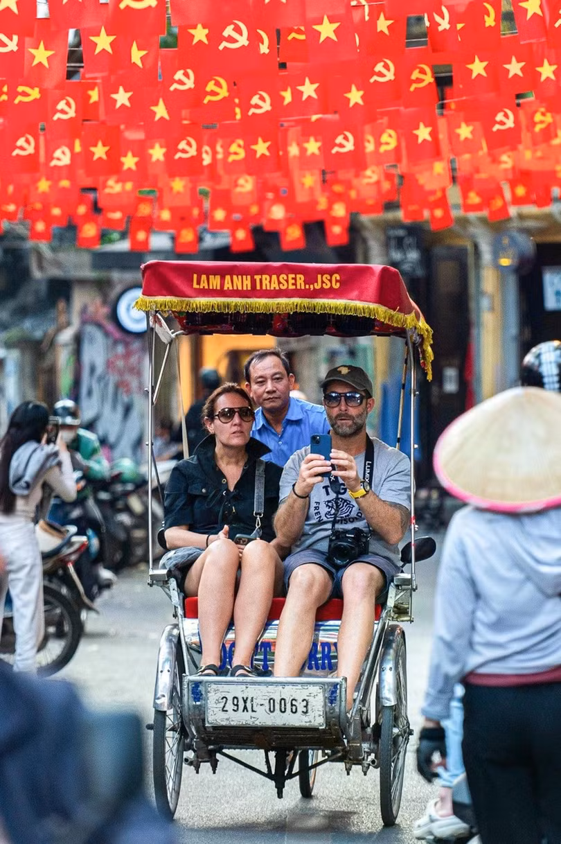 Khách quốc tế ngồi xích lô dạo phố cổ Hà Nội. Ảnh: Đinh Hà.