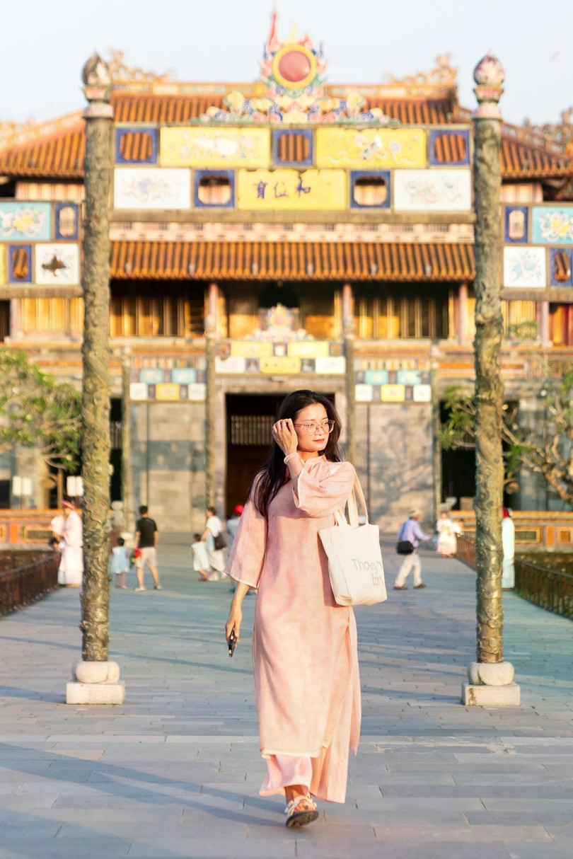 Du khách diện áo dài rảo bước trong Đại nội Huế dưới ánh nắng hè rực rỡ. Ảnh: Linh Huỳnh.