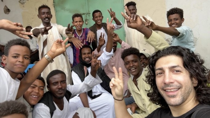 Micheael Zervos ថតរូបជាមួយយុវជននៅ Port Sudan ។ រូបថត៖ កំណត់ត្រាពិភពលោកហ្គីណេស Micheael Zervos chụp ảnh cùng những người trẻ ở Port Sudan. Ảnh: Guinness World Records