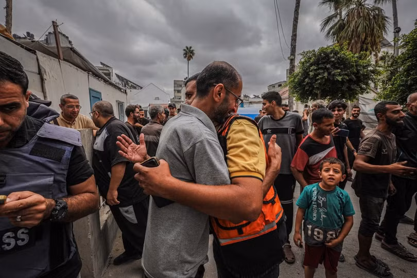 Hai người đàn ông Palestine ôm nhau bên ngoài bệnh viện Al-Ahli Baptist ở Gaza City, miền trung Dải Gaza.