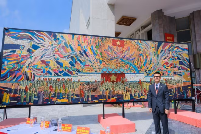Tác giả Chu Nhật Quang bên bức tranh nặng 3 tấn đạt kỷ lục Guinness. (Ảnh: Nhân vật cung cấp)