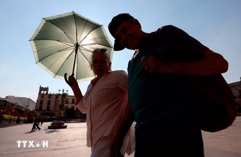 Người dân di chuyển dưới trời nắng nóng tại bang Jalisco, Mexico ngày 9/5/2024. (Ảnh: AFP/TTXVN)