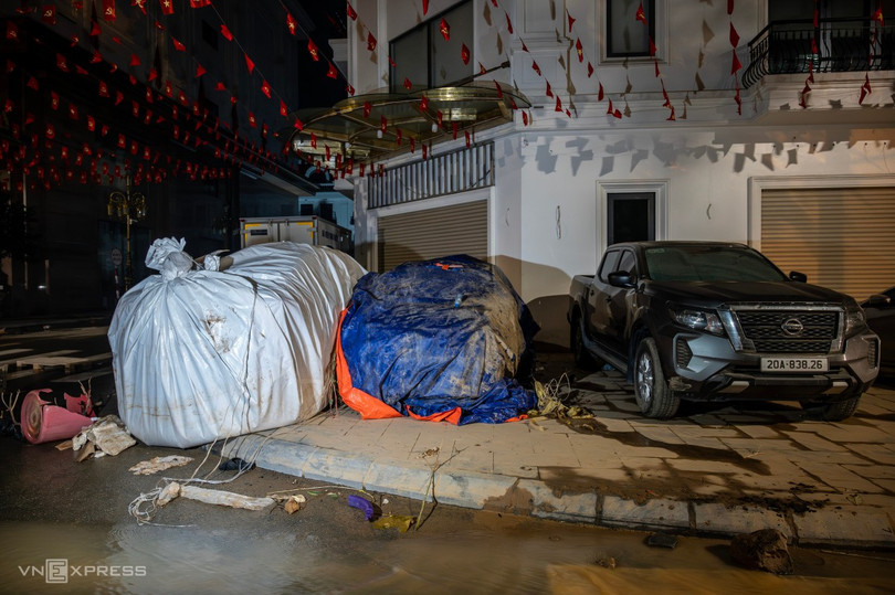 Trên đường Bến Tượng có hai ôtô đã được chủ bọc bạt kín để tránh nước ngập vào xe.