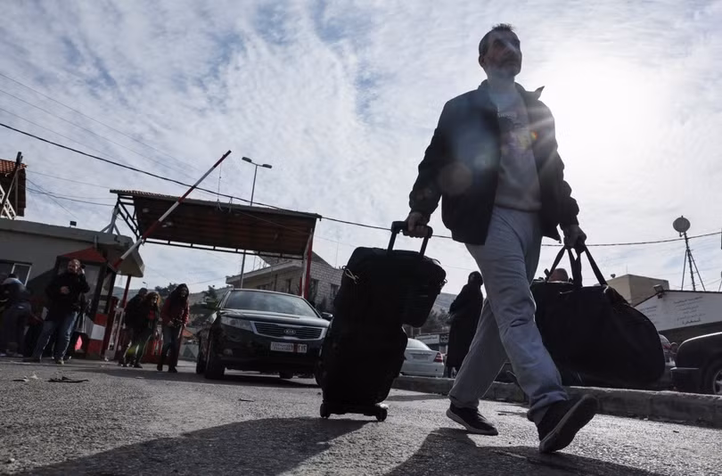 Người đàn ông kéo hành lý tiến vào Lebanon thông qua cửa khẩu Masnaa, sau khi phiến quân tuyên bố lật đổ Tổng thống Bashar al-Assad.