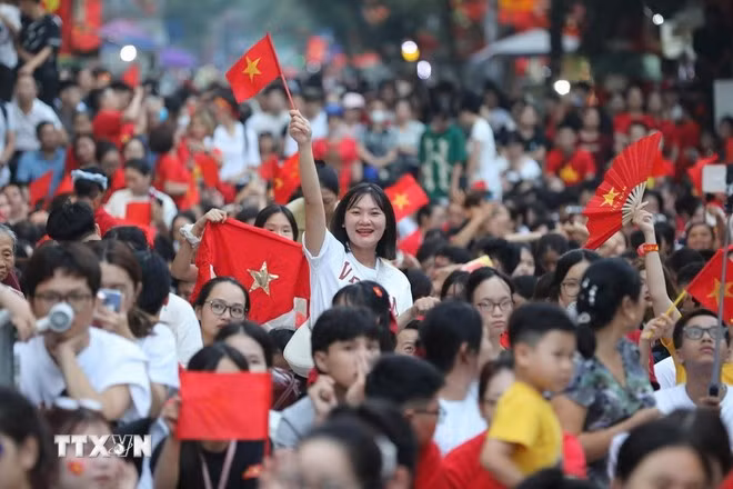 Người dân hân hoan chào đón các khối diễu binh, diễu hành. (Ảnh: Công Đạt/TTXVN)