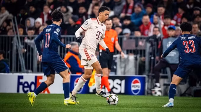 Jamal Musiala đi bóng trước sự truy cản của Vitinha và Warren Zaire-Emery. Ảnh: FC Bayern