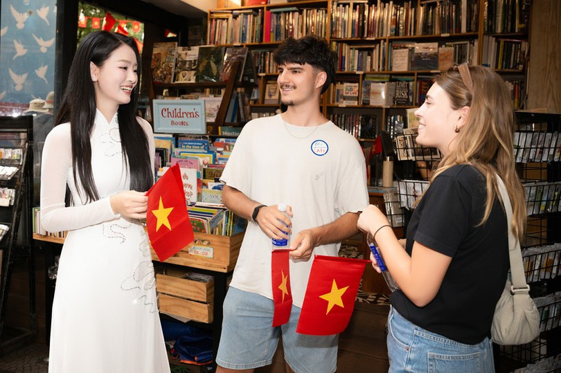 Du khách quốc tế hào hứng vì được tặng lá cờ đỏ sao vàng khi trải nghiệm điểm đến Thành phố Hồ Chí Minh. (Ảnh: CTV/Vietnam+) a-hau-bui-khanh-linh-5.jpg