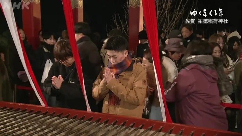 Người dân Nhật Bản cầu nguyện tại chùa Zojo-ji ở Tokyo trong đêm giao thừa sau khi thực hiện phong tục đánh chuông đón năm mới. Được biết đến với tên gọi "Joya no kane", phong tục này là một nghi thức mà các nhà sư sẽ đánh chuông chùa 108 lần như hành động thanh tẩy các ham muốn trần tục. Ảnh: NHK.