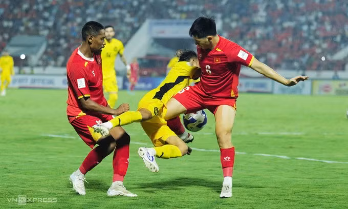 Cao Quang Vinh (trái) và Trần Đình Trọng tranh bóng với Faisal Halim trong trận Việt Nam gặp Malaysia trên sân Thiên Trường. Ảnh: Ngọc Thành