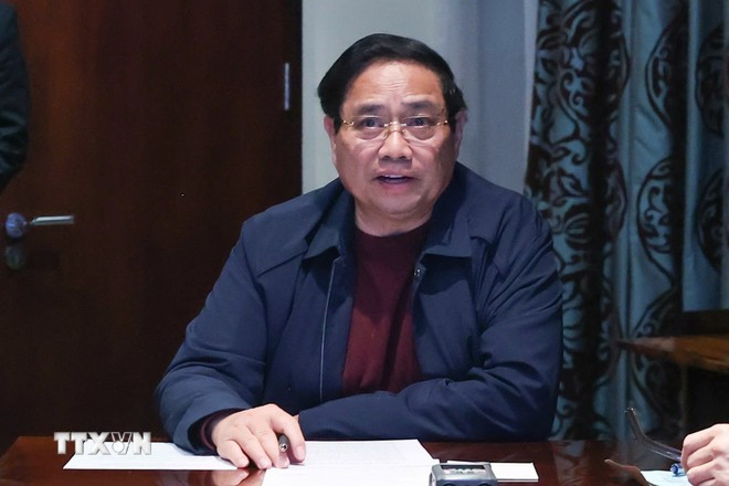 Thủ tướng Phạm Minh Chính chủ trì họp trực tuyến từ Nam Phi, chỉ đạo khắc phục hậu quả mưa lũ. (Ảnh: Dương Giang/TTXVN)